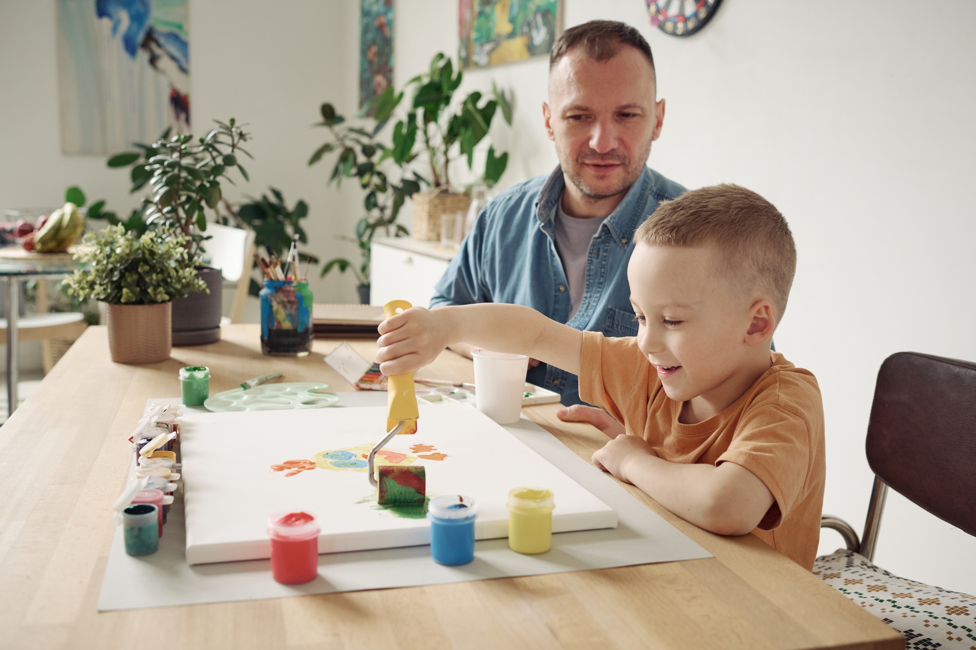 Boy learning to paint with roller