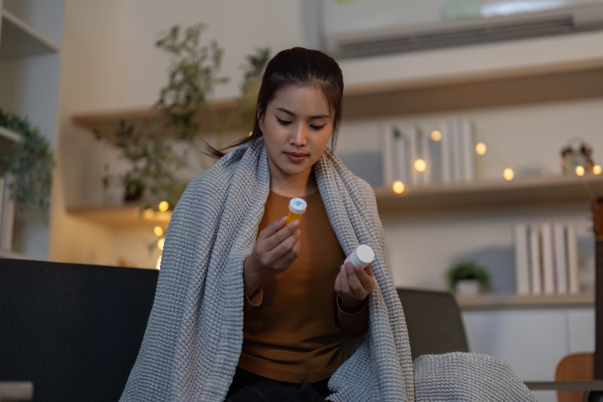 Medication Management. Young woman examining her medication at home.